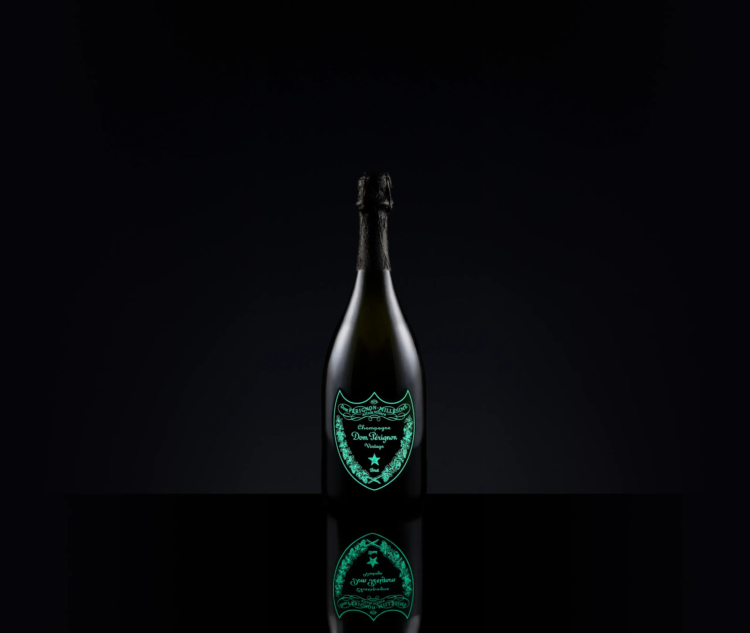 Superchouette- Une bouteille de champagne Dom Pérignon se tient debout sur un fond noir, son étiquette verte brillante se reflétant en dessous, soulignant la forme élégante de la bouteille et la qualité de la marque.