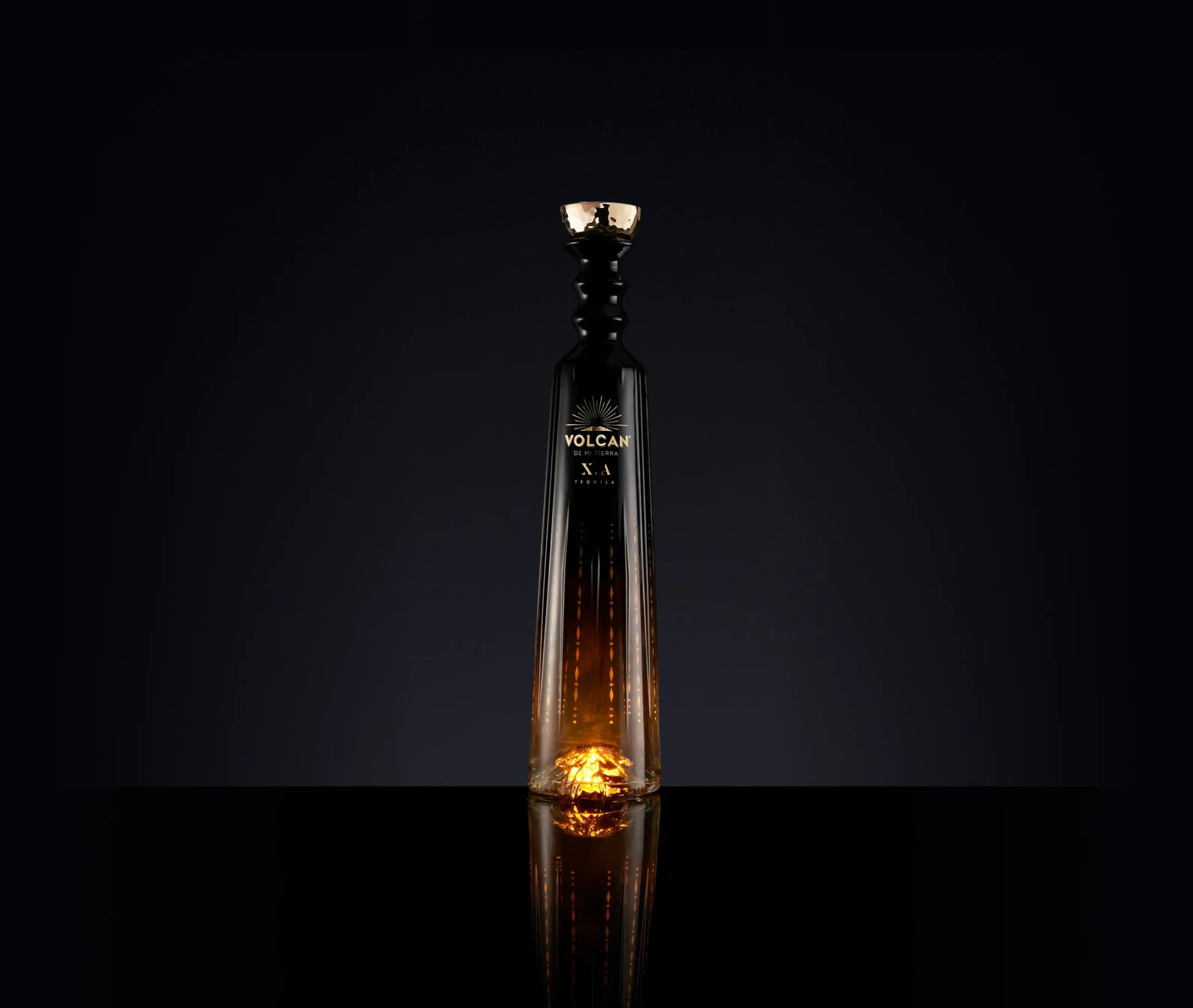 Superchouette- Une grande et élégante bouteille noire avec un bouchon doré se tient debout sur un fond sombre. La bouteille a des accents dorés et brille d'une chaude lumière ambrée à sa base. L'étiquette porte la mention Volcan X.A.