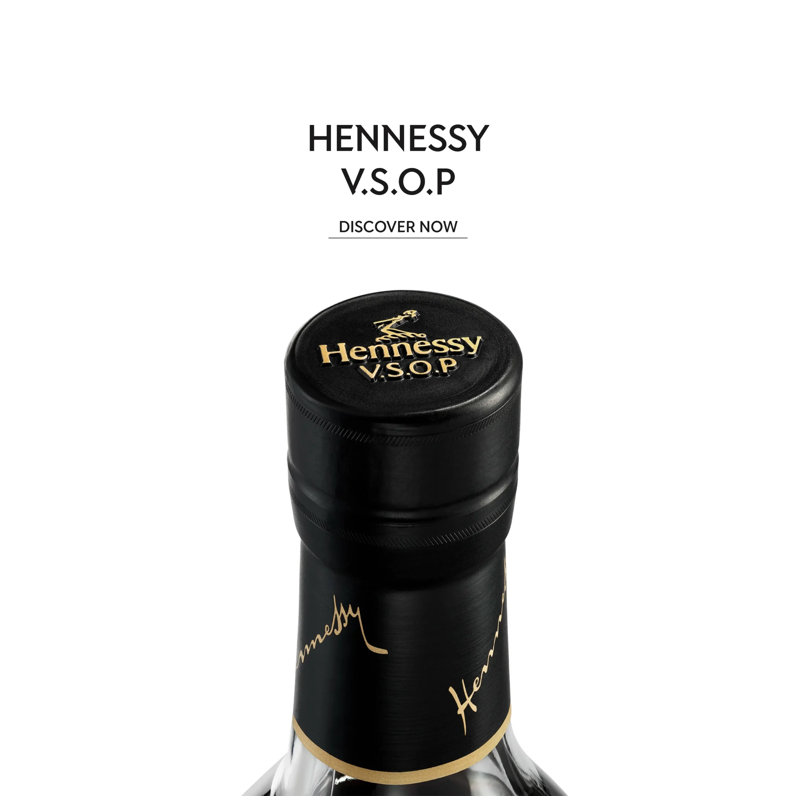 Superchouette- Gros plan d'un bouchon de bouteille Hennessy V.S.O.P avec un lettrage doré, sur fond blanc. Le texte au-dessus indique HENNESSY V.S.O.P DISCOVER NOW.